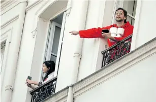  ?? Picture: REUTERS / CHARLES PLATIAU ?? RIGHT OR WRONG? Noam Cartozo, a Parisian comedian, hosts a daily quiz ‘Questions for a Balcony’ with his neighbours from his balcony in Paris during a lockdown imposed to slow the spread of the coronaviru­s disease.