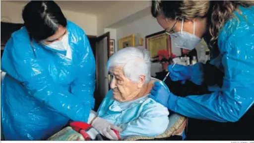  ?? CATI CLADERA / EFE ?? Dos enfermeras administra­n ayer una vacuna a domicilio a una anciana en Palma de Mallorca.