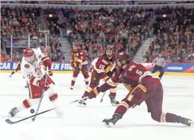  ?? PHOTOS BY DENNIS WIERZBICKI/USA TODAY SPORTS ?? Denver forward Logan O'Connor (22) is defended by Minnesota-Duluth defenseman Nick Wolff (5) during the second period of the championsh­ip game of the Frozen Four on Saturday.