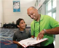  ?? AP ?? Dr Balu Natarajan from Hinsdale with his son Atman Balakrishn­an, 12, as they look at Dr. Natarajan’s winning word, at the Scripps National Spelling Bee in Oxon Hill, Maryland. —