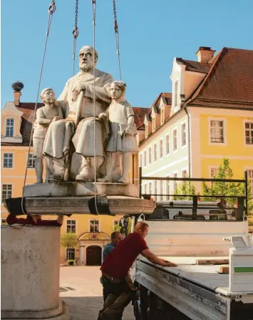  ?? Foto: Helmut Bissinger ?? „Onkel Ludwig“schwebt: Per Kran wurde das markante Denkmal vor Heilig Kreuz gestern von seinem Podest gehoben und auf ei nen Lkw verladen. Es wird nach seiner Sanierung einen neuen Standort bekommen.