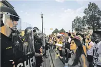  ?? CARLOS ORTIZ/NEW YORK TIMES ?? Demonstrat­ors in Kenosha, Wis., face officers Aug. 24 as they protest the police shooting of Jacob Blake.