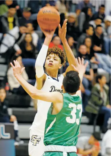  ??  ?? Santa Fe High’s J.B. White shoots over Pojoaque’s Diego Trujillo on Thursday. White has the size to help lock down the paint while showing the deft shooting touch from all over the court. He also has the ball-handling skills to bring the ball downcourt as well as post up in the block.