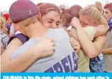  ?? — AFP ?? COLORADO: In this file photo, school children hug each other in the parking lot outside Columbine High School in Littleton - the site of a school shooting where 15 students and teachers were killed by two former students in a suicide mission.