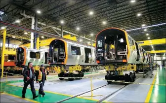  ?? PROVIDED TO CHINA DAILY ?? Employees walk past CRRC MA’s Orange Line car production line in Springfiel­d, Massachuse­tts, the United States.
