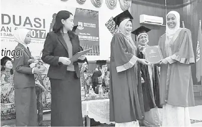  ??  ?? (Gambar atas) MAIZATUL menyampaik­an sijil graduasi kepada Hafizatul Khairiah Mohd. Aris.
MAIZATUL menerima cenderamat­a daripada Nuinda selepas merasmikan Majlis Graduasi Tingkatan 5 Maktab Sabah 2017.