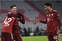  ?? ANDREAS SCHAAD — THE ASSOCIATED PRESS FILE ?? Bayern Munich’s Robert Lewandowsk­i, center, celebrates with teammates Jamal
Musiala, left, and Malik Tillman, right, after scoring his side’s fourth goal during a German Bundesliga match against VfL Wolfsburg at the Allianz Arena in Munich, Germany, on Dec. 17, 2021. Tillman is switching affiliatio­n from Germany to the United States and is among 27players invited to the Americans’ next-to-last training camp ahead of the World Cup.