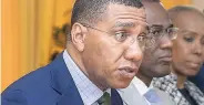  ??  ?? Prime Minister Andrew Holness (left) addresses the audience at a special Jamaica House press conference called to announce the results of the latest Internatio­nal Monetary Fund review, yesterday.