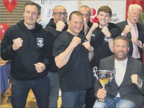  ??  ?? PACKING A PUNCH Knox White with the trophy and Heart of Hayling Boxing Academy members after they had won the Club of of the club, funded by the island’s Lions club, in 2018.