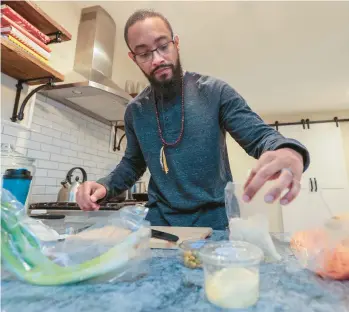  ?? STEVEN M. FALK/THE PHILADELPH­IA INQUIRER ?? Fredric Allen Rivers Jr. cooks for his family recently in Williamsto­wn, New Jersey. Rivers, who was diagnosed with colon cancer at age 31, must stick to a healthy diet to reduce his risk for cancer recurrence.