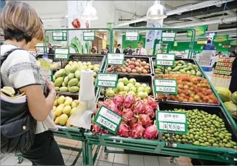  ?? HONG MENEA ?? A woman picks fruits for purchase at a supermarke­t in Phnom Penh last year.