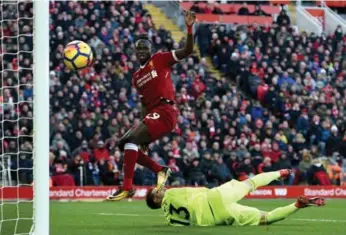  ?? OLI SCARFF/AFP/GETTY IMAGES ?? Liverpool midfielder Sadio Mane flicks a goal past West Ham United goalkeeper Adrian at Anfield on Saturday.