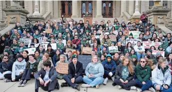  ?? ?? Alumnos y ex alumnos de la Universida­d Estatal de Michigan protestan afuera del Capitolio en Lansing, Michigan