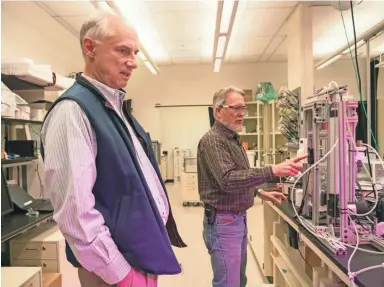  ??  ?? Klaus Lackner (left), director of Arizona State University’s Center for Negative Carbon Emissions, and Allen Wright, the center’s executive director, demonstrat­e the direct-air-capture prototype.