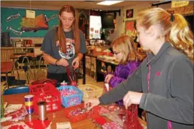  ?? LISA MITCHELL - DIGITAL FIRST MEDIA ?? Fleetwood students Sarah Reitnauer, grade 8; Ava Jenkins, grade 5; and Emily Miller, grade 5, make Valentine care packages for troops on Martin Luther King Jr. Day, Jan. 15.