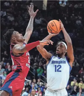  ?? MICHAEL CONROY/AP ?? Memphis forward Deandre Williams (12) shoots over Florida Atlantic guard Brandon Weatherspo­on (23) in the first half of a first-round college basketball game in the men’s NCAA Tournament in Columbus, Ohio, on Friday.