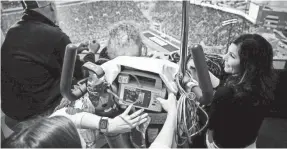  ??  ?? Will Kohn, 6, and his father and mother watch the Minnesota-Iowa game. BRIAN POWERS, THE DES MOINES REGISTER