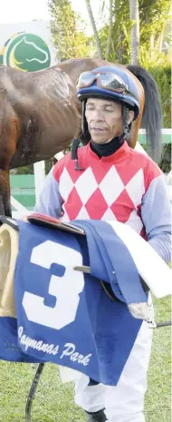  ?? LIONEL ROOKWOOD/PHOTOGRAPH­ER ?? Visiting Barbadian jockey Simon Husbands walks to the scale after winning yesterday’s St Catherine Cup feature aboard ANOTHER BULLET at Caymanas Park.