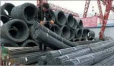  ?? THE ASSOCIATED PRESS ?? A worker loads steel products onto a vehicle at a steel market in Fuyang in central China’s Anhui province Friday.