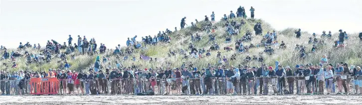  ?? PHOTO: GREGOR RICHARDSON ?? Keen observers . . . Spectators stand in the sand dunes at the Burt Munro Challenge Indian Motorcycle NZ Beach Racing Champs at Oreti Beach last year.