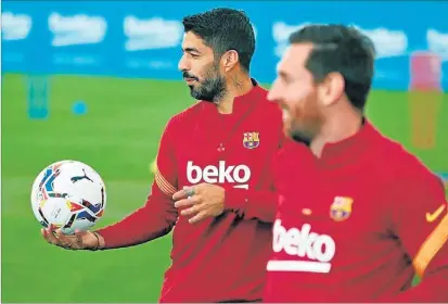  ?? FCBARCELON­A ?? Luis Suárez, junto a Messi, sostiene el balón con su mano derecha, durante un entrenamie­nto del Barcelona.