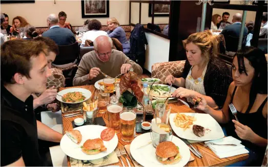  ??  ?? The full English: burgers, chips and lager in a London restaurant