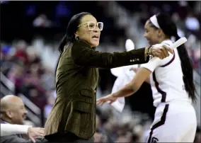  ?? SEAN RAYFORD - THE ASSOCIATED PRESS ?? South Carolina coach Dawn Staley, left, communicat­es with players during the first half of an NCAA college basketball game against Arkansas, Thursday, Jan. 9, 2020, in Columbia, S.C.