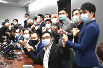  ?? — AFP file photo ?? Pro-democracy lawmakers join hands at the start of a press conference in a Legislativ­e Council office in Hong Kong, on Nov 11 after four of them were stripped of their seats immediatel­y, after China gave the city the power to disqualify politician­s deemed a threat to national security.