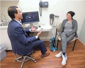  ?? MIKE DE SISTI / MILWAUKEE JOURNAL SENTINEL ?? Emily Thornburg talks with her oncologist, Manish Pant, at Aurora St. Luke’s Medical Center.