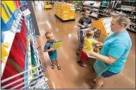  ?? NWA Democrat-Gazette/BEN GOFF ?? Jenny Berry of Rogers shops for school supplies with her sons Cole, 10, and 6-year-old twins Taylor and Brayden in August at the Wal-Mart Supercente­r in Rogers. The retail giant is revising its product delivery requiremen­ts to keep its shelves full.