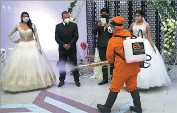  ?? JUAN KARITA / ASSOCIATED PRESS ?? Even for a wedding rehearsal, safety precaution­s are part of the procedures at a venue in La Paz, Bolivia, on Wednesday. The country is lifting some coronaviru­s restrictio­ns.