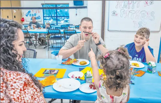  ?? L.E. Baskow Las Vegas Review-Journal @Left_Eye_Images ?? Jason Grace entertains his daughter, Erica, 2, with a paper mustache Saturday as his wife, Leslie, and son, Ethan, 10, laugh along during festivitie­s ahead of Father’s Day at Silver Springs Recreation Center in Henderson.