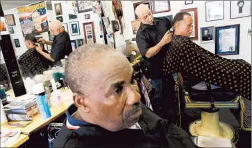  ?? Barbara Davidson
Los Angeles Times ?? SOUTH L.A. BARBER Lawrence Tolliver, center, shown in April 2012, was “very, very pleased” by the NBA’s lifetime ban on Donald Sterling. With him are barber Yusuf Muhammad and customer Gregory Metoyer.