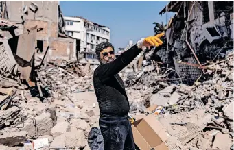  ?? | SAMEER AL-DOUMY AFP ?? TURKISH optician Cuneyt Eroglu, 45, points to his father’s collapsed shop in Antakya on Saturday. A 7.8-magnitude earthquake struck near Gaziantep, Türkiye, in the early hours of February 6, followed by a 7.5-magnitude tremor. The quakes caused widespread destructio­n in southern Türkiye and northern Syria and has killed more than 44 000 people so far.