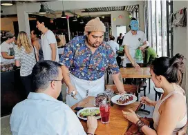  ?? [AP FILE PHOTO] ?? Jason Joshua waits on customers at Zak the Baker in Miami. Retail and restaurant workers are receiving more generous raises than manufactur­ing workers.