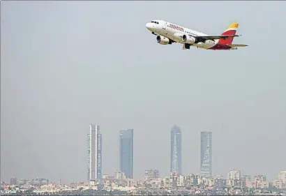  ?? PAUL HANNA / REUTERS ?? Un avión de Iberia, sobre el cielo de Madrid