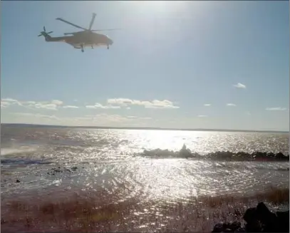  ?? SUBMITTED ?? A Cormorant helicopter from Greenwood search and rescue hovers above a breakwater on the Cobequid Bay in Highland Village on Tuesday. The aircraft was used to rescue one of two bass fishermen, who became trapped on the rocks by the incoming tide.