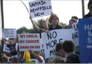  ?? PAM PANCHAK — PITTSBURGH POST-GAZETTE ?? A group of students and parents rally in front of Hempfield Area High School in Greensburg, Pa., protesting the first day of the state-wide policy requiring masks to be worn in K-12schools and day cares.