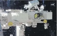  ?? NASA THE ASSOCIATED PRESS ?? In this image from video made available by NASA, astronaut Drew Feustel prepares to close a door to an atmospheri­c experiment during a space walk outside the Internatio­nal Space Station .
