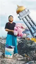  ??  ?? ... A woman holds a stuffed rabbit toy found at her destroyed home where she said she had lost her three children, in Palu on Sunday.