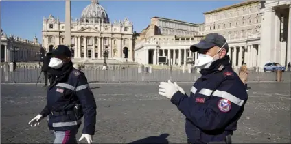  ?? AP PHOTO/ANDREW MEDICHINI ?? Police o cers wearing masks patrol an empty St. Peter’s Square at the Vatican, on Wednesday.