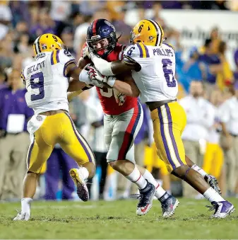  ?? AP Photo/Gerald Herbert ?? ■ Mississipp­i tight end Dawson Knox (9) is swarmed by LSU safety Grant Delpit (9) and linebacker Jacob Phillips (6) in the second half Saturday in Baton Rouge, La. LSU won, 45-16.