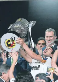  ??  ?? FESTEJO. Dani Parejo levanta el trofeo conseguido, mientras es observado por el rey Felipe.