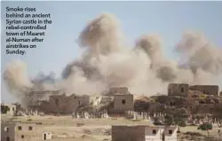  ??  ?? Smoke rises behind an ancient Syrian castle in the rebel-controlled town of Maaret al-Numan after airstrikes on Sunday.