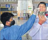  ??  ?? A health worker collects the swab sample of a passenger at CSMT on Monday.