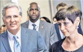  ??  ?? OUT: Rep. Kevin McCarthy, above Thursday with wife Judy, dropped out amid allegation­s of an affair with Rep. Renee Ellmers (left).