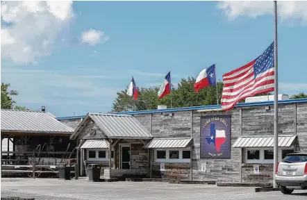  ?? Steve Gonzales / Houston Chronicle ?? Lone Star Grill in Bacliff flew its American flag at half-staff on Tuesday, the day after it was learned that owners Greg and Julie Boaz were killed in a weekend plane crash in Michigan.