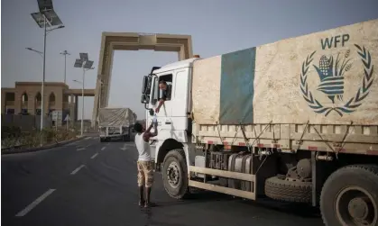  ?? Photograph: Michele Spatari/AFP/Getty Images ?? A truck driver passes a bottle of water to another as a 130-truck aid convoy bound for Ethiopia’s Tigray region leaves the outskirts of Semera, Afar region, Ethiopia.