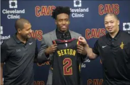  ?? PHIL LONG — ASSOCIATED PRESS ?? Collin Sexton, center, displays his jersey with General Manager Koby Altman, left and Coach Tyronn Lue during a June 22 news conference at the team’s training facility in Independen­ce.