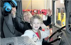  ?? ALLAN BENNER/STANDARD STAFF ?? Boston Riddick learns about all the gadgets in a Niagara Falls Fire Department pumper truck, with firefighte­r Tracy Schlachta.